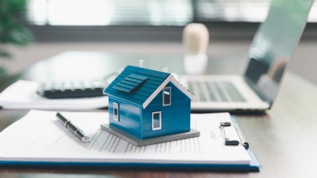 A small home placed on top of papers to indicate a property tax notice
