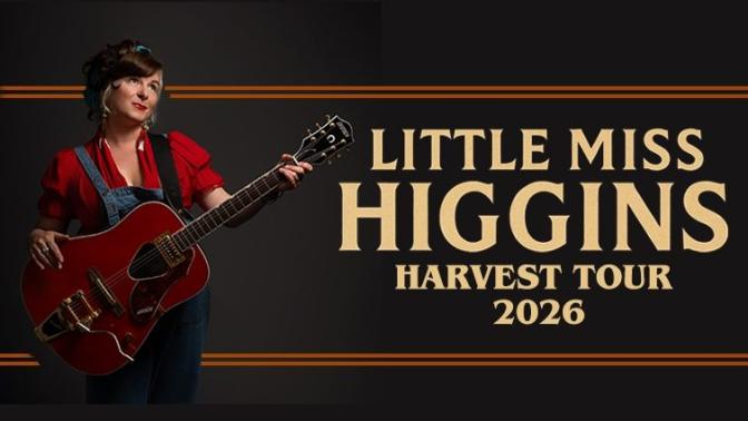 country blues artist little miss higgins posed with her guitar, wearing a red top and denim overalls, looking skyward