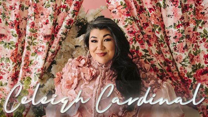 musician Celeigh Cardinal posed in a pink floral backdrop wearing a ruffled pink dress standing with one hand on her hip