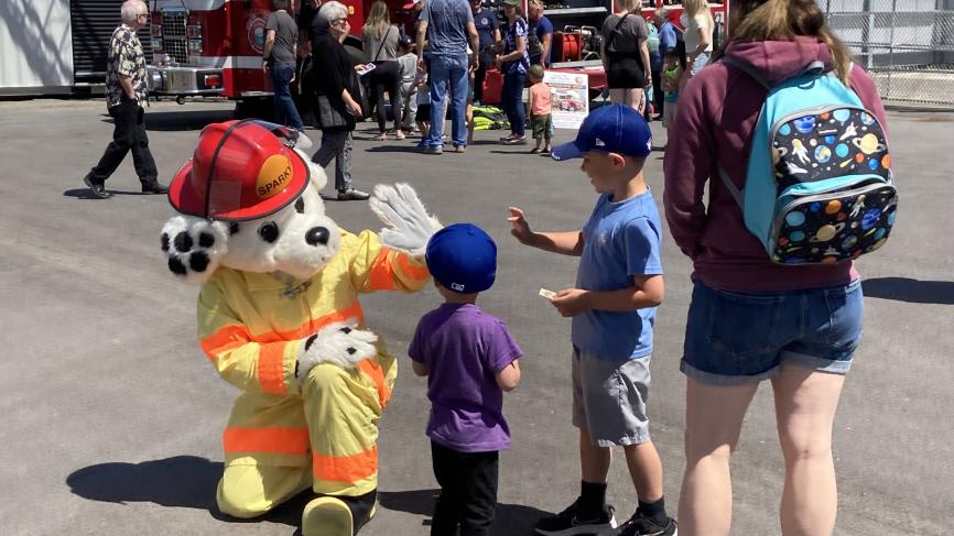 Sparky the Fire Dog gives a high five to children at Fire Hall Open House event