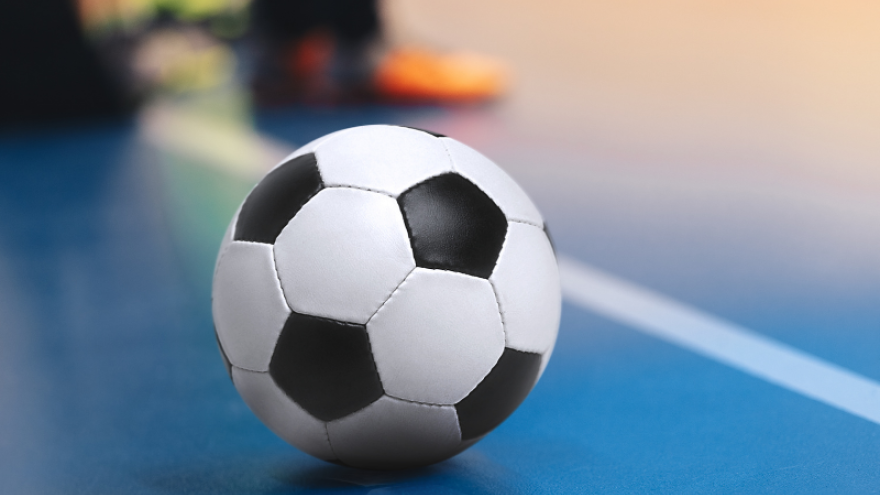 A soccer ball on the floor of an indoor court