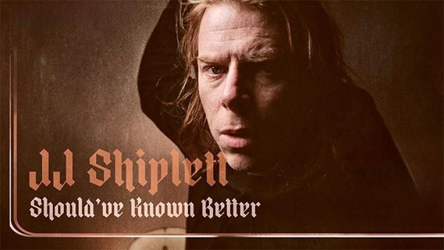 MOody sepia tone portrait of JJ Shiplett gazing directly at the photographer from over his shoulder