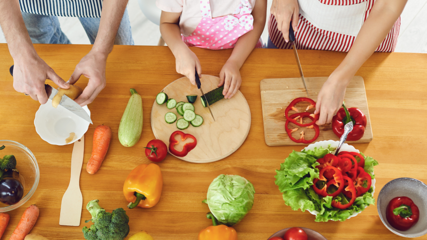 three sets of hands chopping on cutting boards