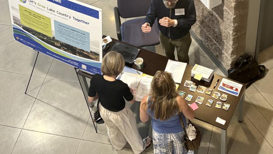 Planner welcomes two people to an open house event