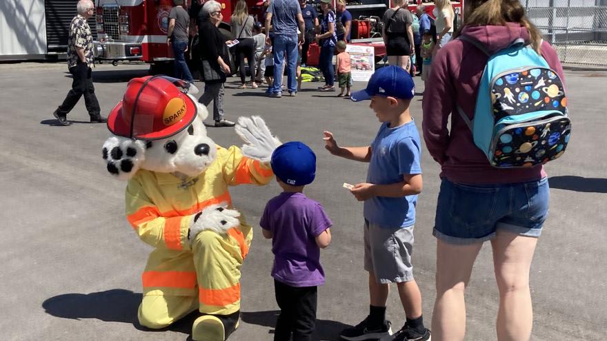 Sparky the Fire dog gives a high five to children at the Fire Hall