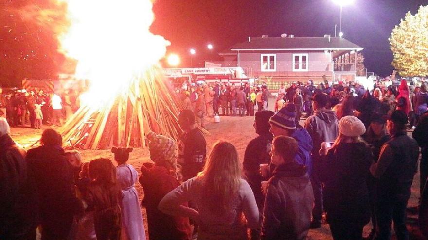Halloween bonfire with community members watching