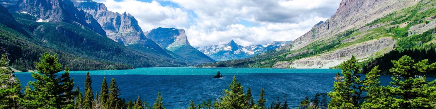a mountain lake with blue skies and trees