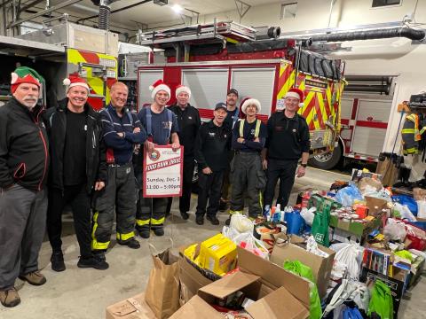 firefighters wearing Santa hats with donations for Food Bank