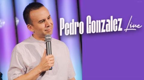 portrait of colombian comic pedro gonzalez on stage holding a microphone, He is wearing a beige tshirt, with a smile on his face and his head tilted to the left. He is standing in front of a pastel purple and light blue backdrop