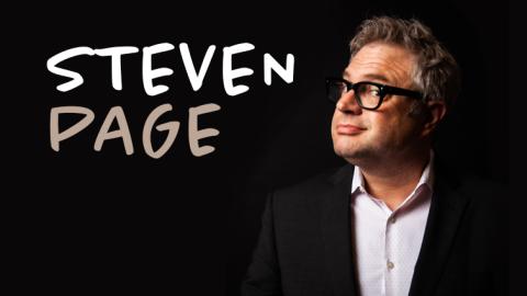 portrait of Canadian singer Steven Page looking to the side wearing a white button up shirt and black suit jacket with his signature dark framed glasses