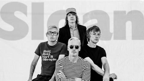 black and white portrait of the 4 members of the band Sloan, all seated with serious expressions