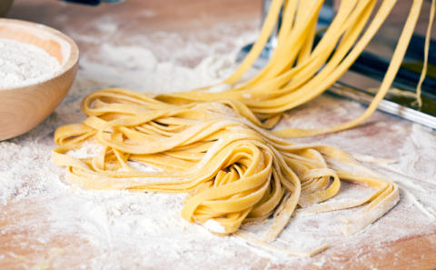 A manual pasta machine with spaghetti