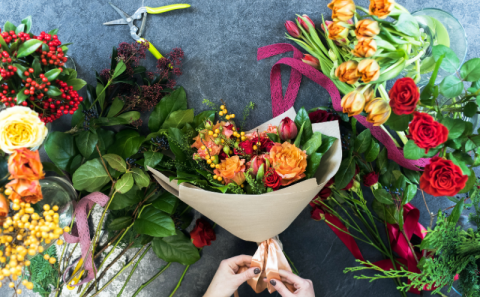 Female hands put together a flower bouquet 