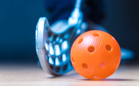 Floor hockey stick and ball with holes in it