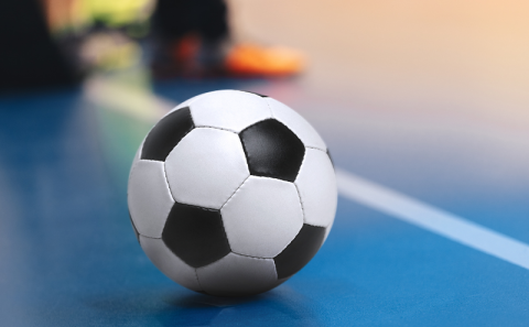 A soccer ball on the floor of an indoor court