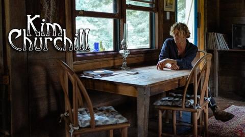 Kim Churchill Sitting at a Table