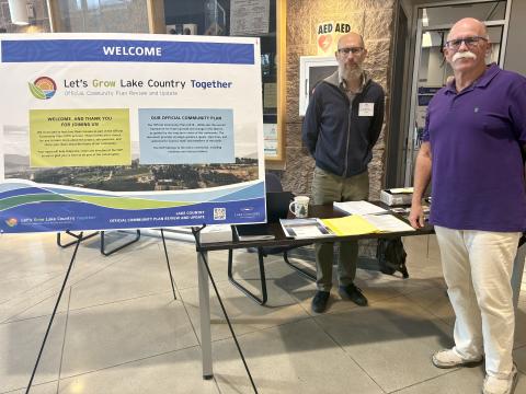 Mayor and Planner stand beside sign welcoming public to open house