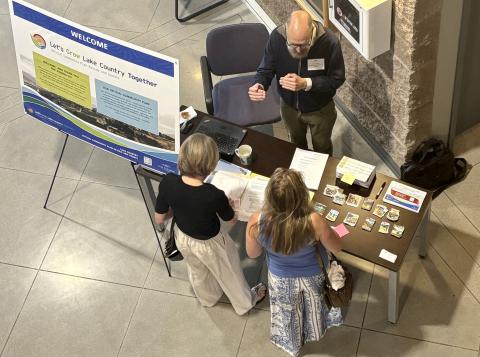 Planner welcomes two people to an open house event