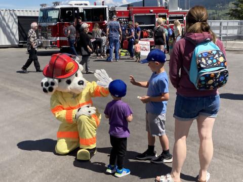 Sparky the Fire dog gives a high five to children at the Fire Hall