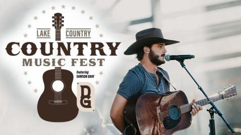 Country artist Dawson Gray signing at a microphone holding a guitar