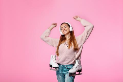 Girl listening to music with ice skates 