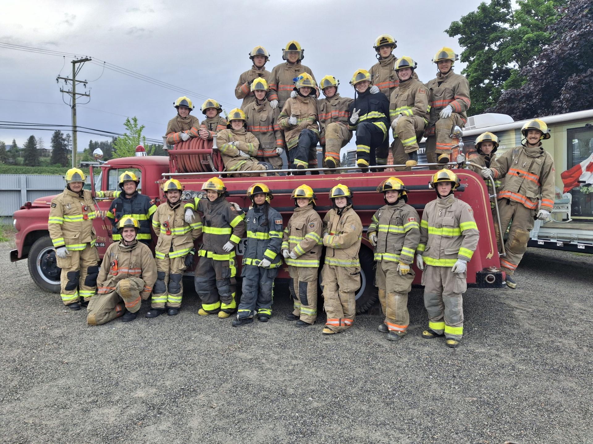 junior firefighters post by old fire truck